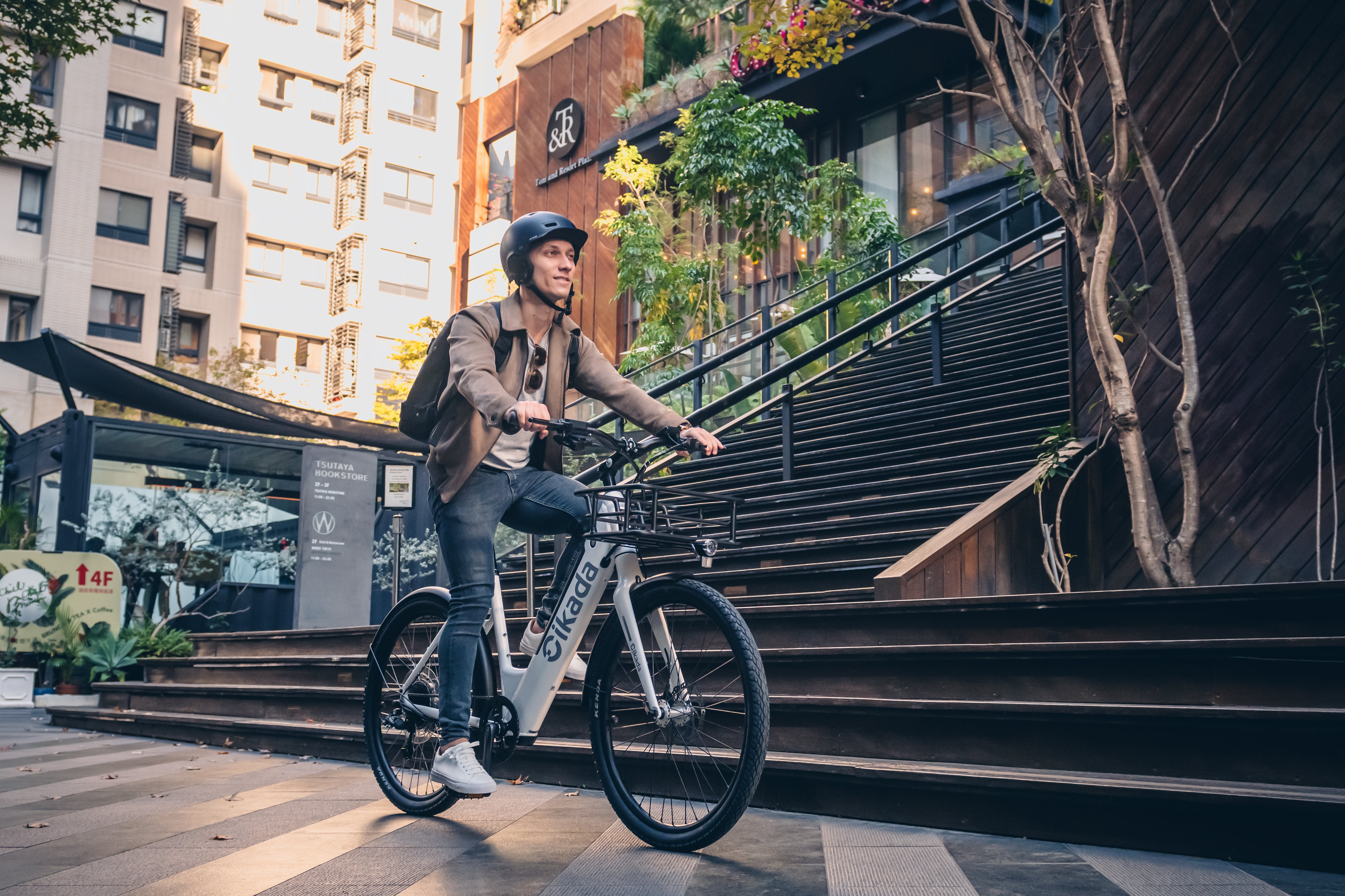 Young man with a helmet is riding a Cikada City e-bike through the city.