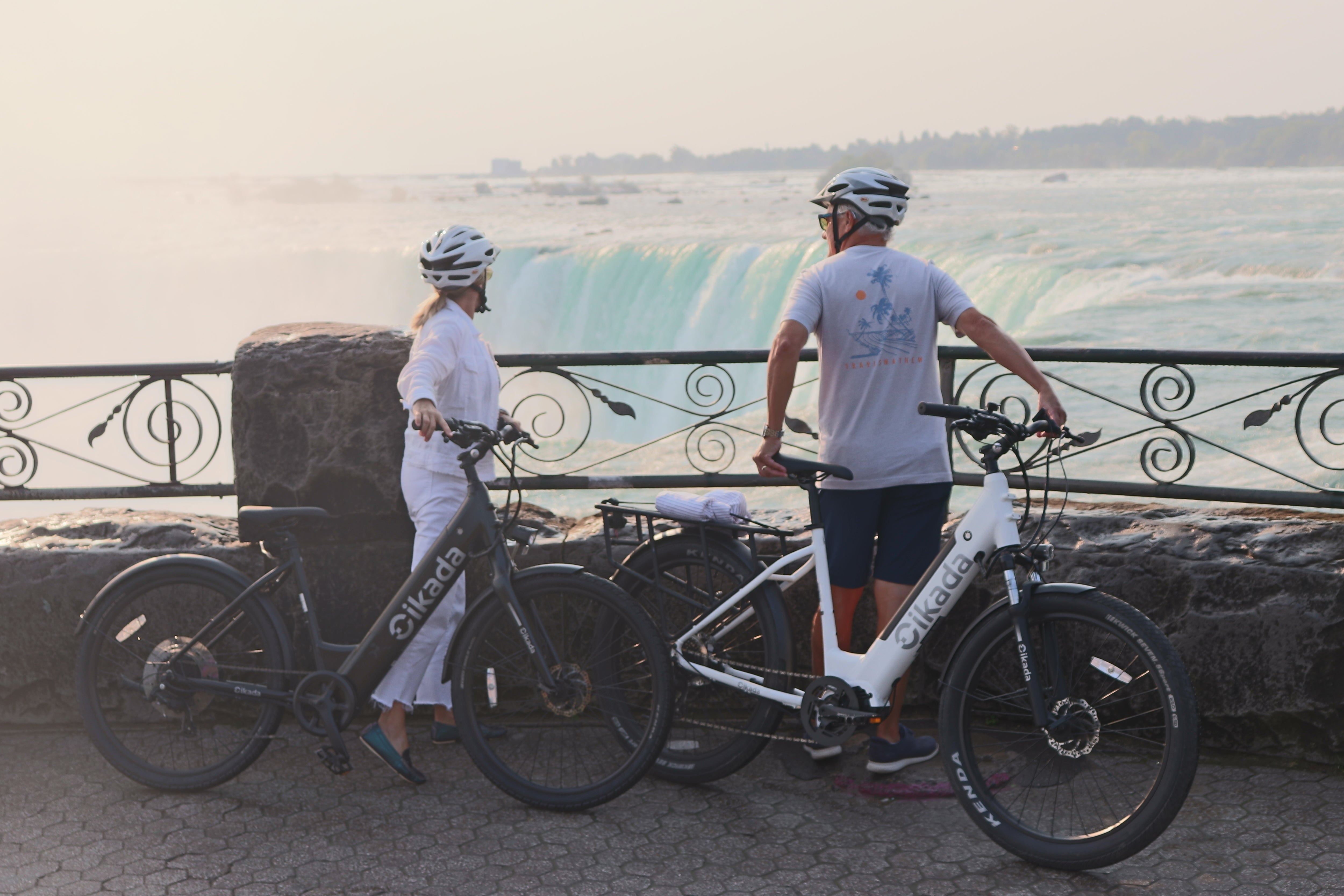 A couple of elderly people standing with their Cikada eBike next to Niagara Falls.