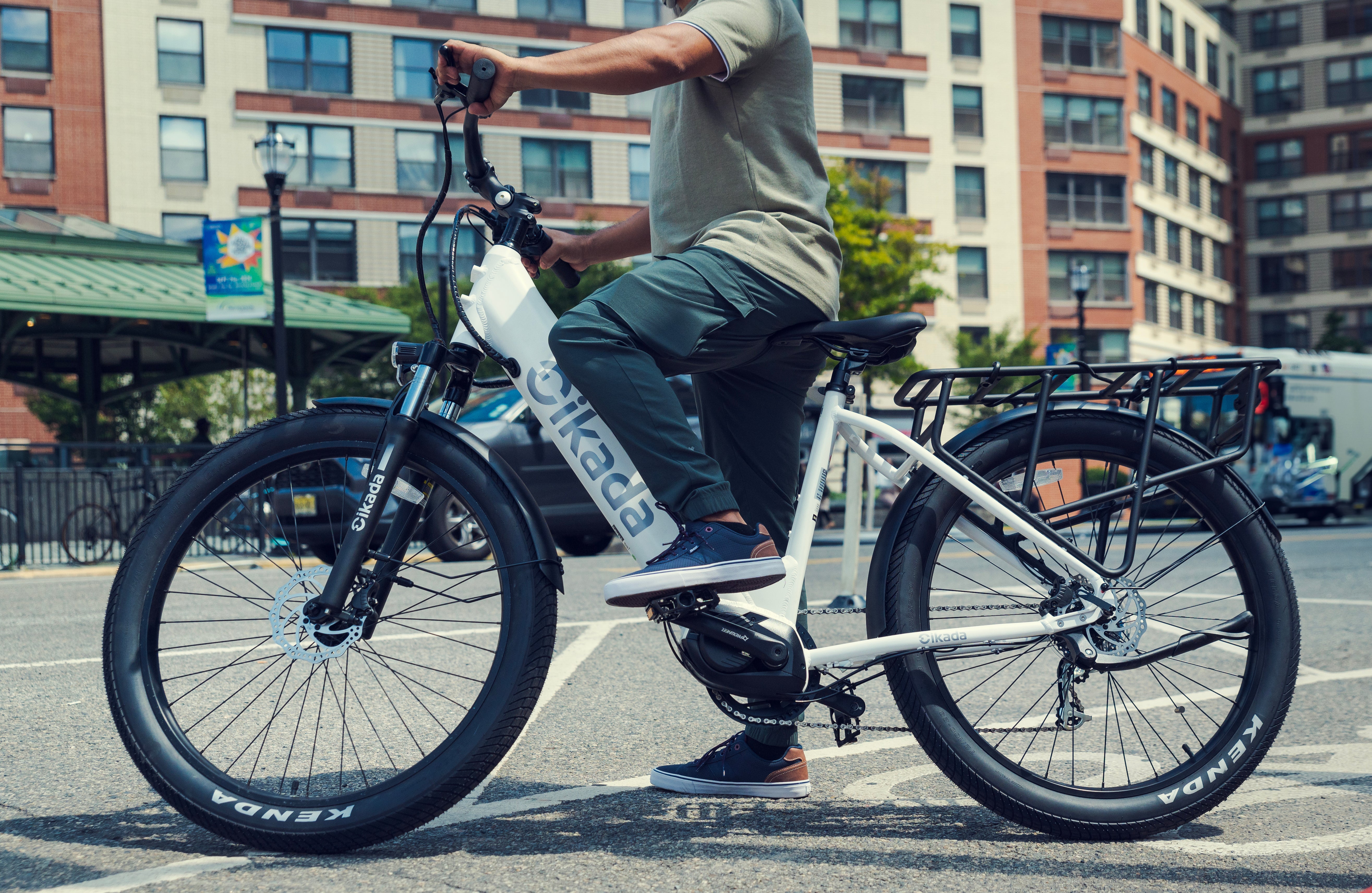 A man is riding a Cikada Touring e-bike on the streets of New Jersey.