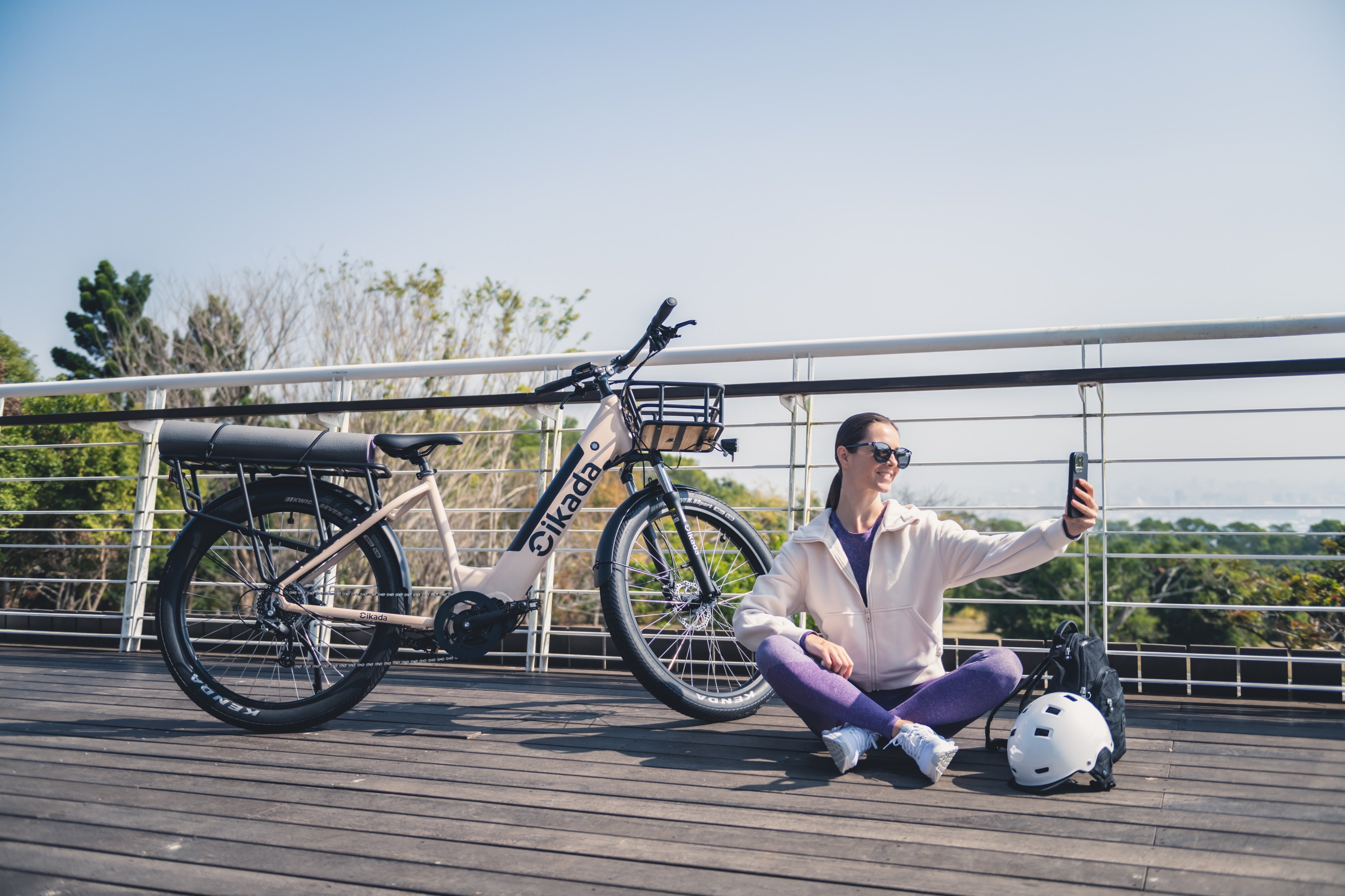 Young lady is taking a selfie with her new Cikada Touring e-bike outdoor.